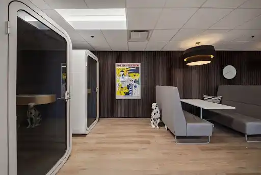 Caption: Acoustic isolation booths eliminate background noise during high-stakes client pitches.